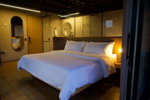 a bedroom with a large bed with white sheets and pillows at Casa Leon Hotel R Top in Rionegro