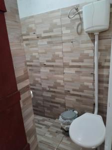 a bathroom with a toilet and a tile wall at Vila Sol & Mar Gaibu PE in Cabo de Santo Agostinho +66 photos
