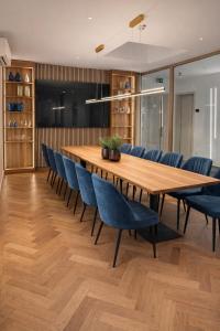 a dining room with a wooden table and blue chairs at MSLiving Hotels in Hannover