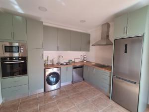 a kitchen with green cabinets and a washer and dryer at Sol de Infantes in Villanueva de los Infantes