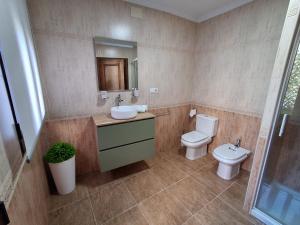 a bathroom with a toilet and a sink and a mirror at Sol de Infantes in Villanueva de los Infantes +15 photos