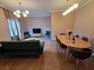 a living room with a table and a green couch at Sol de Infantes in Villanueva de los Infantes