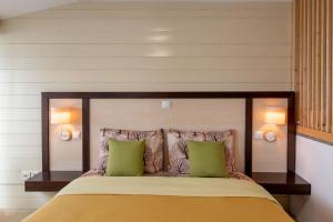 a bedroom with a large bed with two green pillows at Lakeview Sunset Kastoria in Kastoria