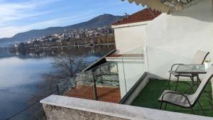 a balcony with a table and chairs and a view of the water at Lakeview Sunset Kastoria in Kastoria