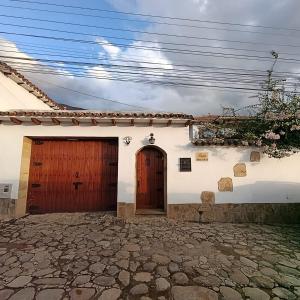 a white house with two wooden doors on it at Hotel Boutique Villa Amonita in Villa de Leyva