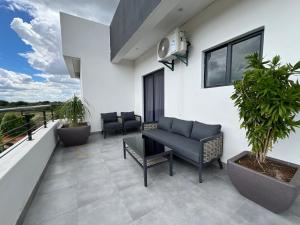 a patio with a couch and chairs on a balcony at Casa-Pel Villa Grande in Palatswe