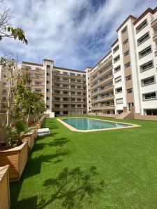 an apartment complex with a lawn and a swimming pool at Luxury By Sana in Agadir