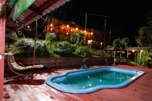 a swimming pool on a wooden deck at night at Angatu Amazon Jungle Lodge in Iranduba