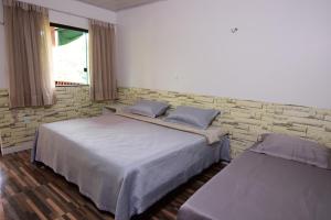 a bedroom with two beds and a brick wall at Angatu Amazon Jungle Lodge in Iranduba +27 photos