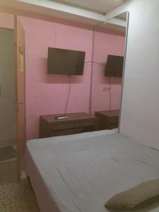 a bedroom with a bed and a pink wall at Hospedagem Setúbal in Recife