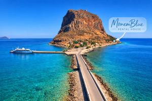 a road in front of a mountain in the ocean at MonemBlue in Monemvasia