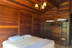 a room with a bed in a wooden room at Quintal da Serra in Morretes