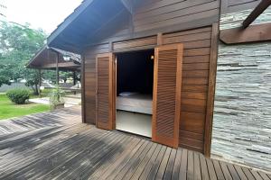a bed is inside of a building on a deck at Quintal da Serra in Morretes