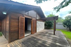 a house with wooden doors and a wooden deck at Quintal da Serra in Morretes