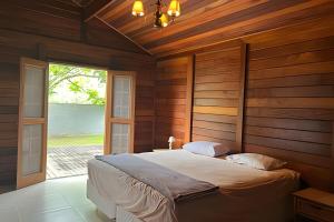 a bedroom with a bed with a wooden wall at Quintal da Serra in Morretes