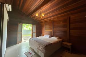 a bedroom with a bed in a room with wooden walls at Quintal da Serra in Morretes +57 photos