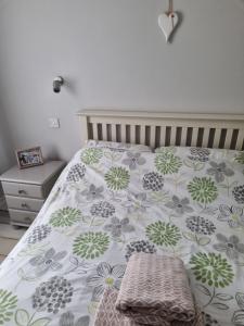 a bedroom with a bed with a floral bedspread at Beachside Apartment in Bangor