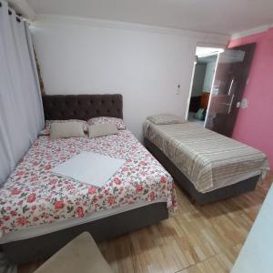 a small bedroom with two beds and a mirror at Hospedagem Setúbal in Recife