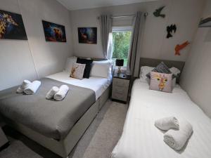 two beds in a room with white sheets and pillows at Sherwood 33 in Carnforth +43 photos
