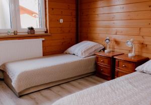 two beds in a room with wooden walls at DOM U Stefanów - Królowy Most in Królowy Most