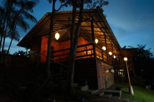 a wooden house with lights on it at night at Angatu Amazon Jungle Lodge in Iranduba