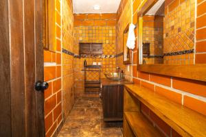 a bathroom with orange tiled walls and a mirror at Hotel Spa Bliss Guatape in Guatapé +182 photos