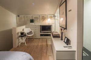 a bedroom with a bed and a desk with a television at Sleep At Slim Amsterdam in Amsterdam