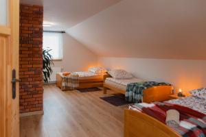 a attic room with two beds and a couch at Gajówka Wiry in Pawłowa