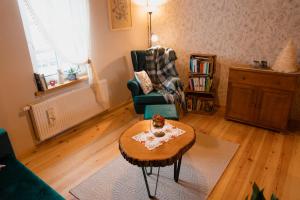 a living room with a coffee table and a chair at Gajówka Wiry in Pawłowa