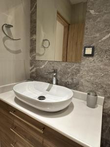 a bathroom with a white sink and a mirror at Panorama Serenity Suites in Thessaloniki +8 photos