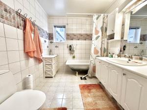 a bathroom with a tub and a toilet and a sink at Arctic Getaway Sørvågen - King Crab Welcome Gift in Sørvågen +22 photos