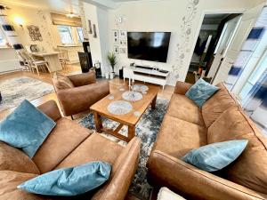 a living room with two brown couches and a table at Arctic Getaway Sørvågen - King Crab Welcome Gift in Sørvågen