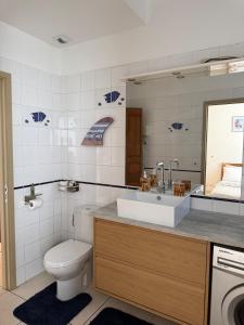 a bathroom with a toilet and a sink at Ora Stay in Papeete +18 photos