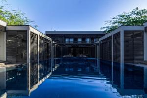 a swimming pool in front of a house at 99 Surf Lodge in El Limón