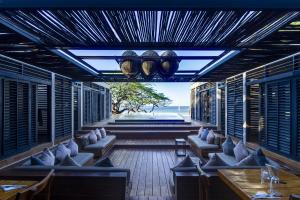 a restaurant with couches and a view of the ocean at 99 Surf Lodge in El Limón