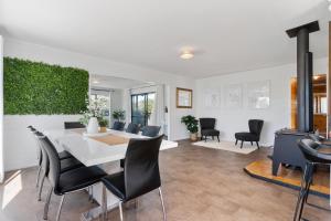 a dining room and living room with a table and chairs at Lockwood on Cologne in Martinborough