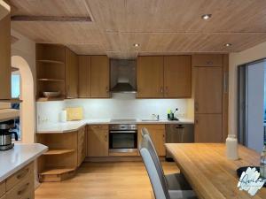 a kitchen with wooden cabinets and a wooden table at Aviva SEEPANORAMA - Großzügige 85m Wohnung mit Bodenseeblick in Bodman-Ludwigshafen
