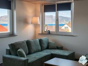 a living room with a couch and two windows at Aviva SEEPANORAMA - Großzügige 85m Wohnung mit Bodenseeblick in Bodman-Ludwigshafen