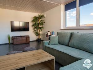 a living room with a couch and a table at Aviva SEEPANORAMA - Großzügige 85m Wohnung mit Bodenseeblick in Bodman-Ludwigshafen