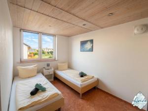 a room with two beds and a window at Aviva SEEPANORAMA - Großzügige 85m Wohnung mit Bodenseeblick in Bodman-Ludwigshafen