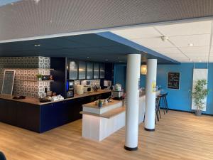 a kitchen with blue walls and columns in a room at Les Tourelles - Chalets & Chambres en Bord de Mer in Asnelles
