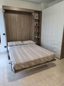 a bedroom with a bed with a wooden wall at Casa dei Mazzoni in Crema