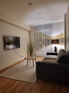 a living room with a couch and a table at To Be Apartament Palanga in Palanga