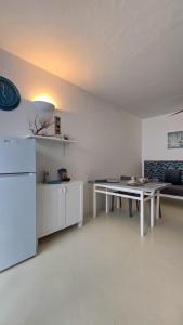a white living room with a table and a couch at Casa Albacora in Sal Rei