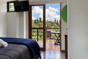 a bedroom with a bed and a view of a balcony at Hotel Mirador Cielo Azul in Horizonte