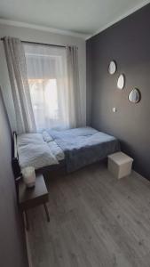 a bedroom with a bed with a window and a table at Apartament Elizabeth in Głubczyce