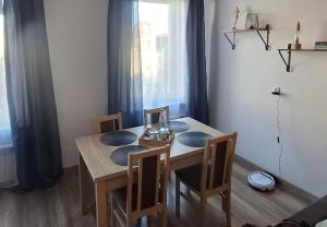 a dining room table and chairs in a room with a window at Apartament Elizabeth in Głubczyce