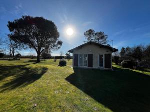 a small house in a field with a tree at T2 charmant dans les Landes in Lesperon