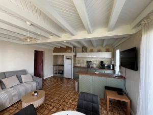 a living room with a couch and a kitchen at T2 charmant dans les Landes in Lesperon