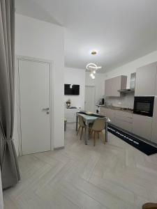 a white kitchen with a table and a dining room at OLYMPO HOUSE senza balcone in Agrigento